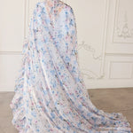 Flowing white cape with delicate blue and pink floral print pattern.