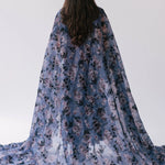 The High Priestess Victorian Cloak designed with a blue and purple floral print called Antique Floral and made entirely of Soft Poly Organza fabric.