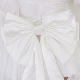 White large satin bow with crisp, structured folds.