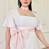 The Ivory Cloud Day Dress with flutter sleeves and a pink bow sash at the waist.