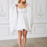 A white polyester lace dress with long flowy sleeves and a square neckline.