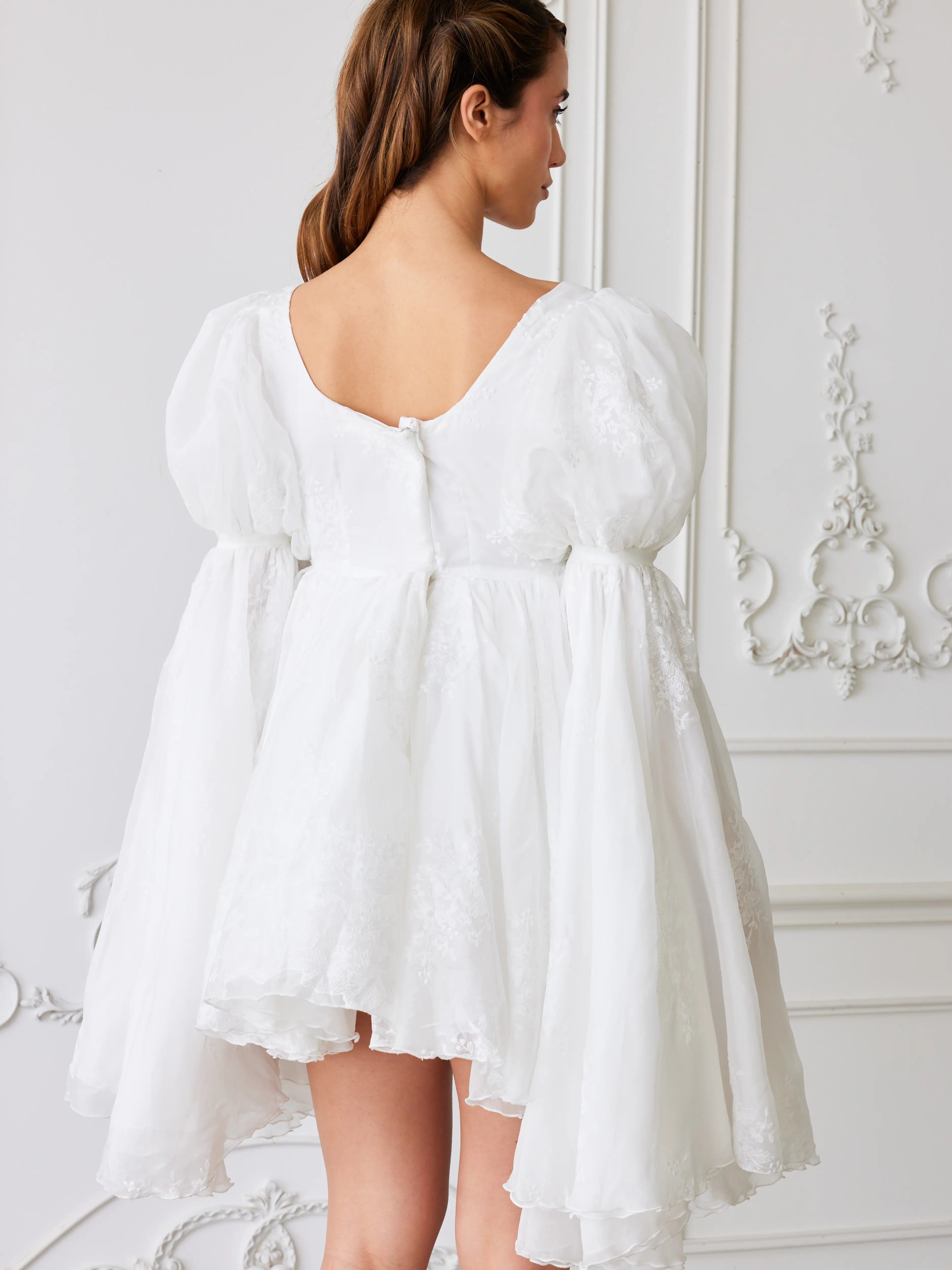 White puff-sleeve dress with a flared skirt and back zipper detail.