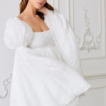 A white puff-sleeved mini dress with a square neckline.