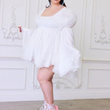 A white mini dress with oversized lace sleeves paired with pink ballet heels.