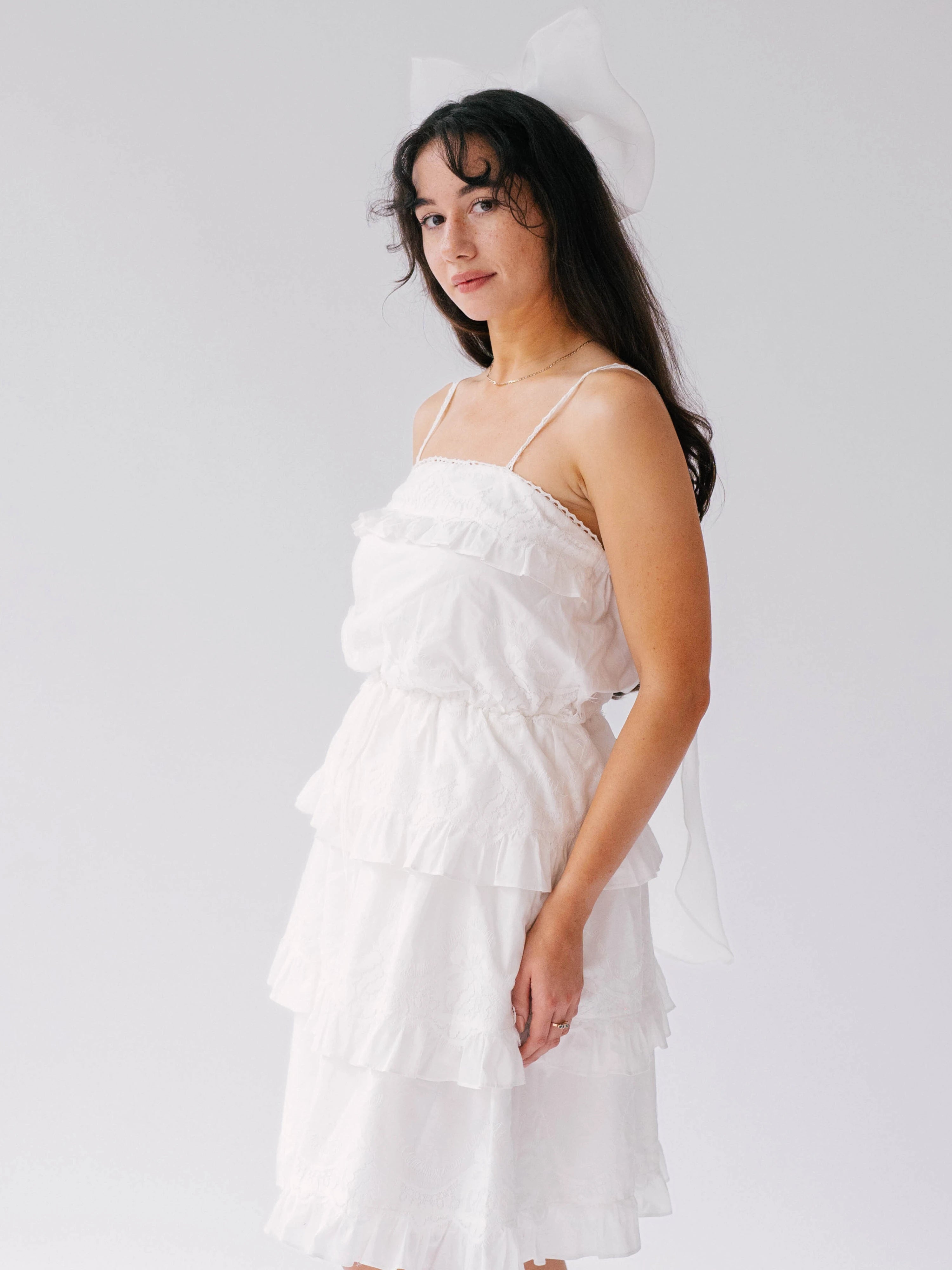 White tiered ruffle dress with thin straps and The Ivory Grand Bridal Hair Bow