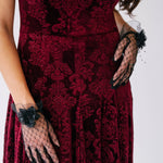 Scarlet red velvet midi dress with ornate damask patterns and black lace evening gloves.