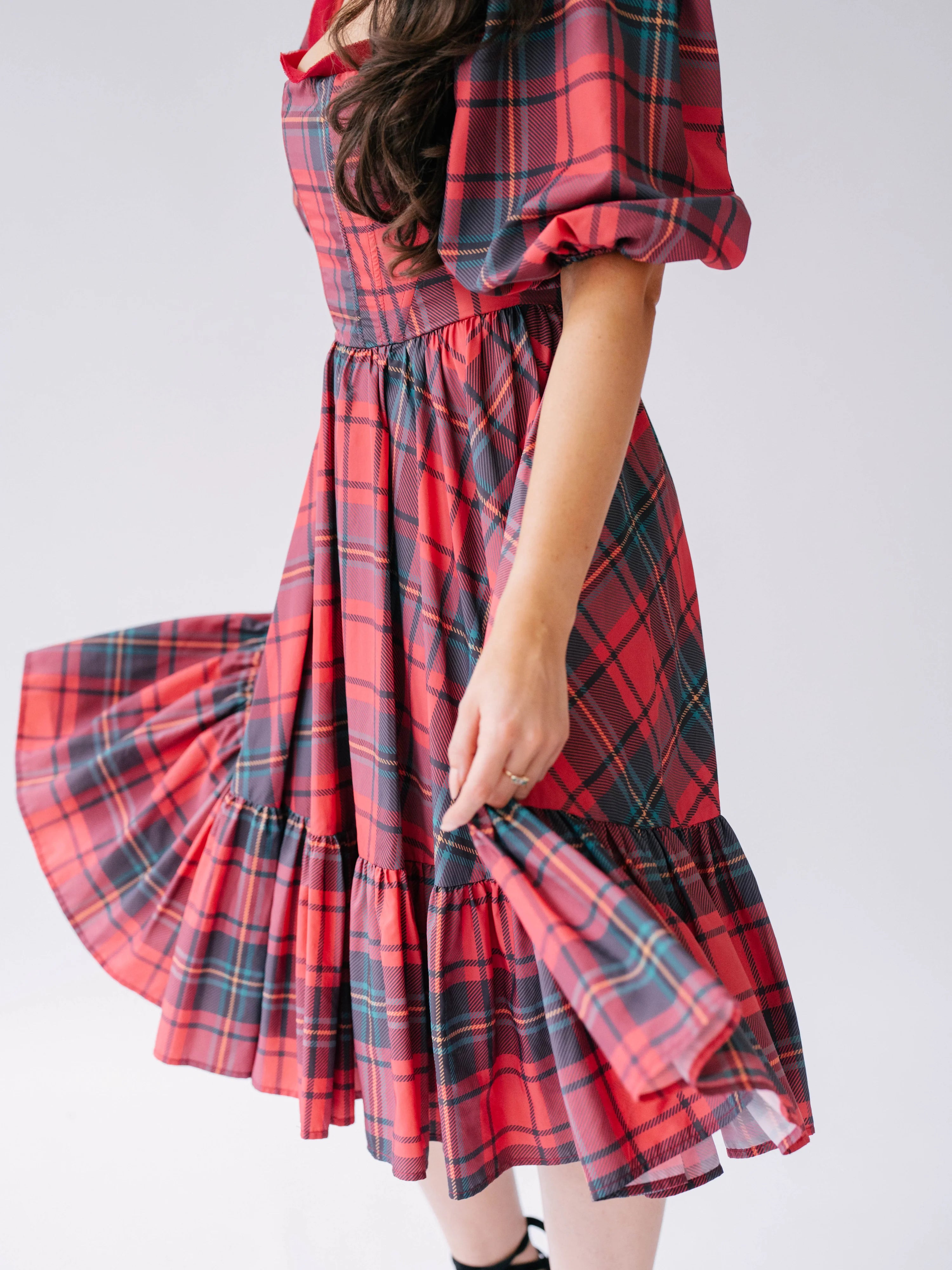 Red plaid corset midi dress with puffed sleeves and tiered ruffle skirt.