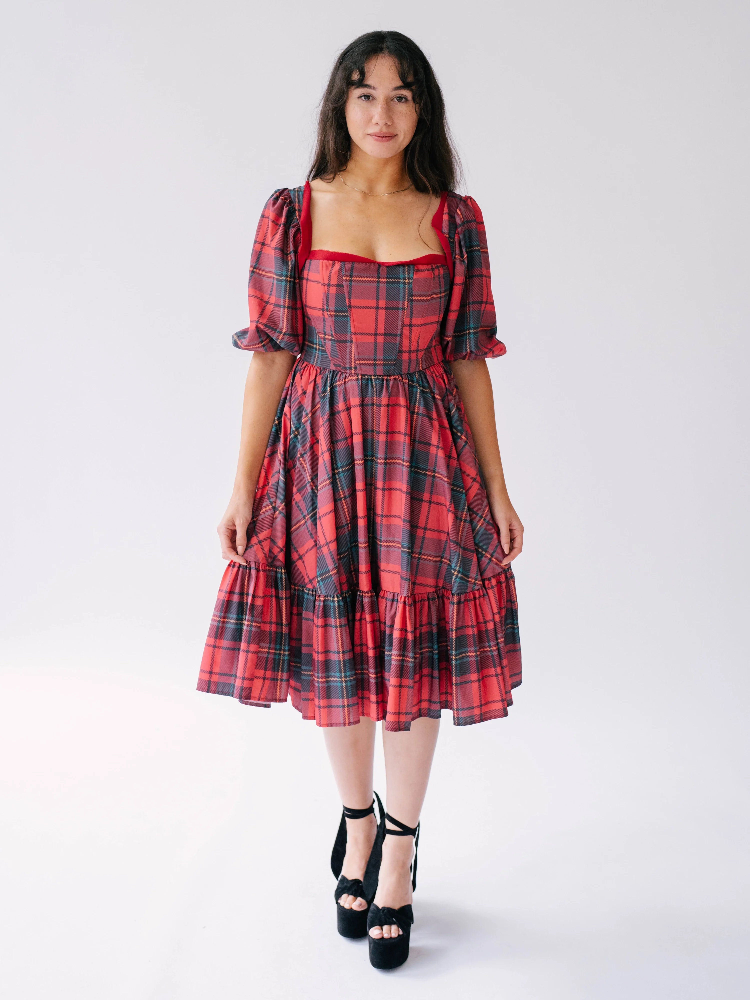 Red plaid midi dress with puff sleeves and tiered skirt.