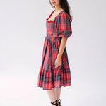 Red plaid holiday midi dress with puff sleeves and a tiered skirt.