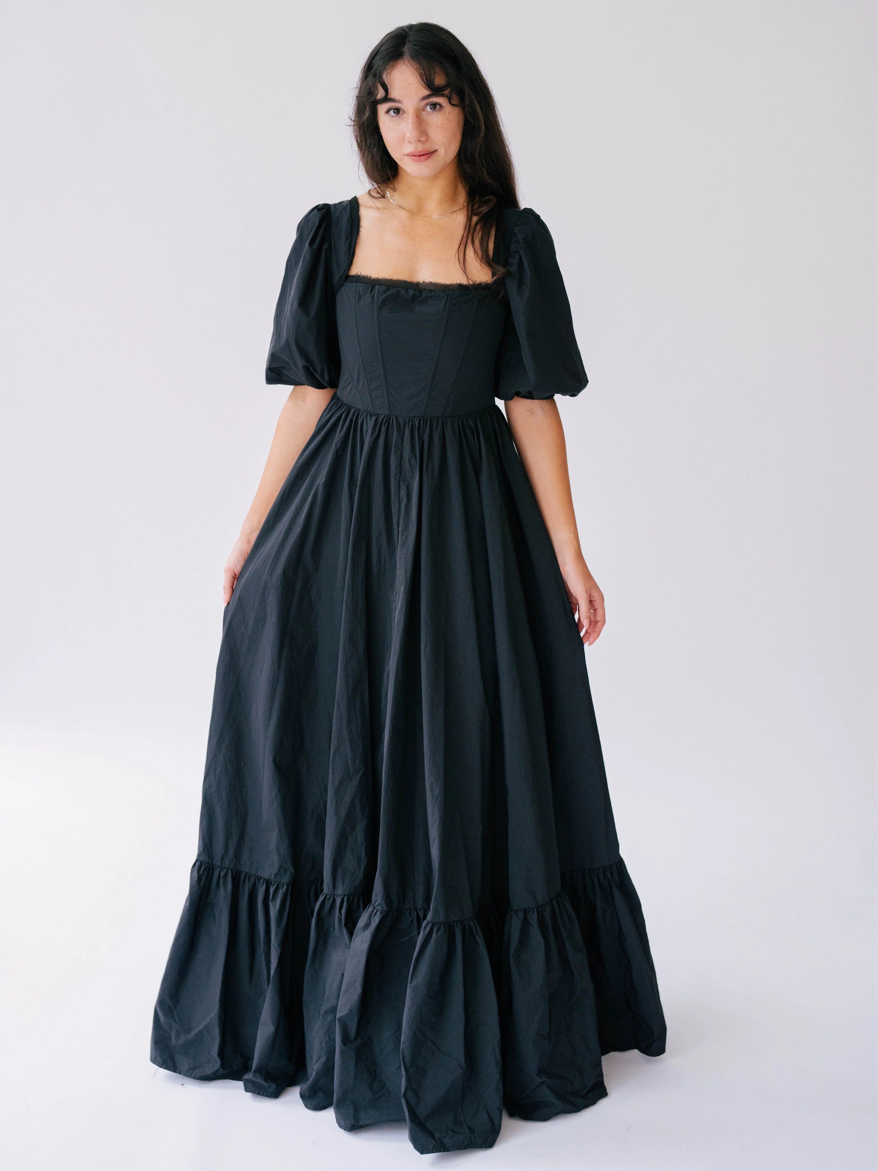 Black taffeta maxi dress with puff sleeves and a tiered ruffle hem.
