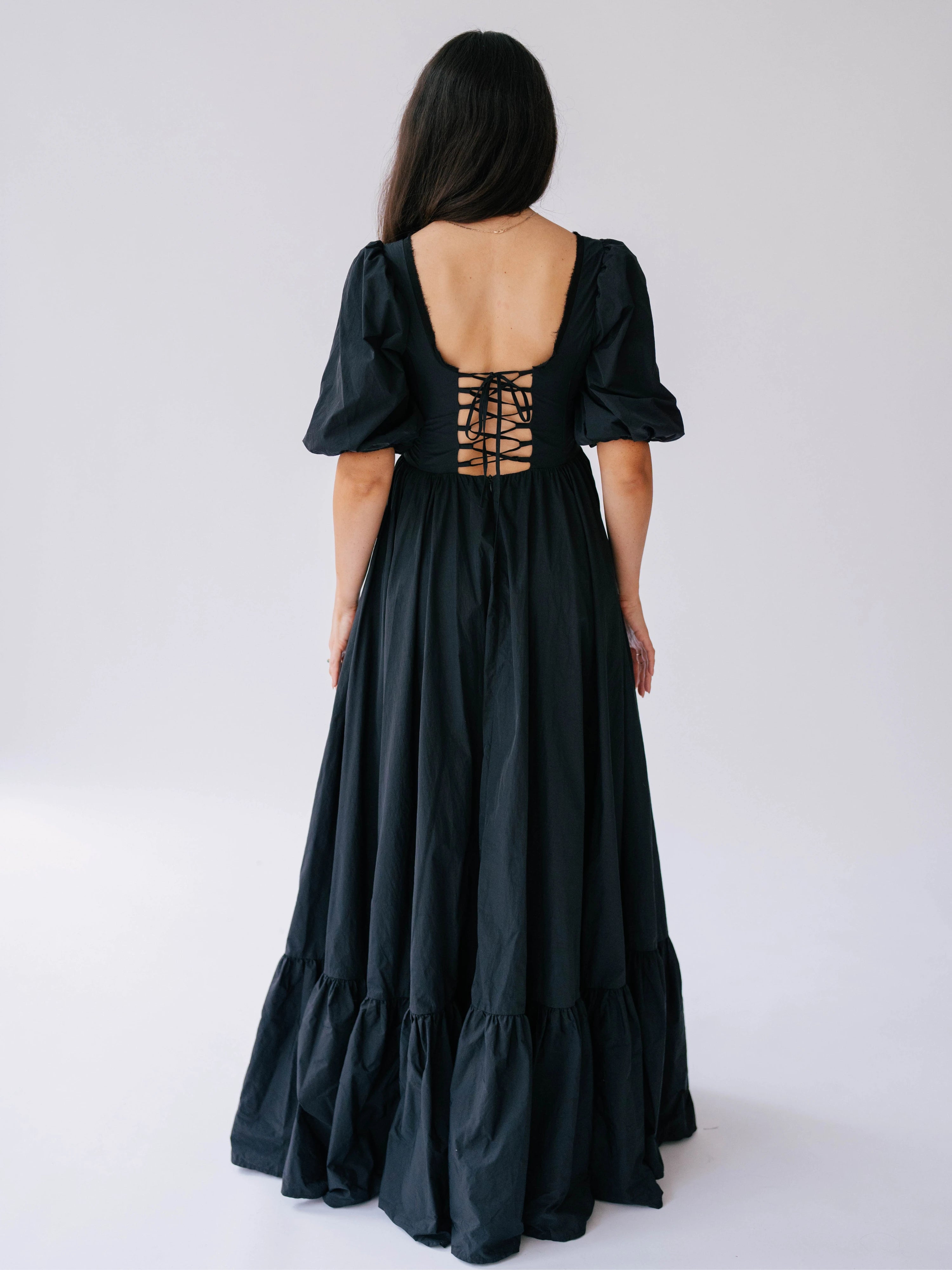 Black renaissance gown with puff sleeves and corset-style lacing on the back.