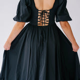 Black corset-style bodice maxi dress with puff sleeves and a lace-up back.