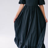 Black taffeta corset renaissance gown with puff sleeves and a tiered, flowing skirt.