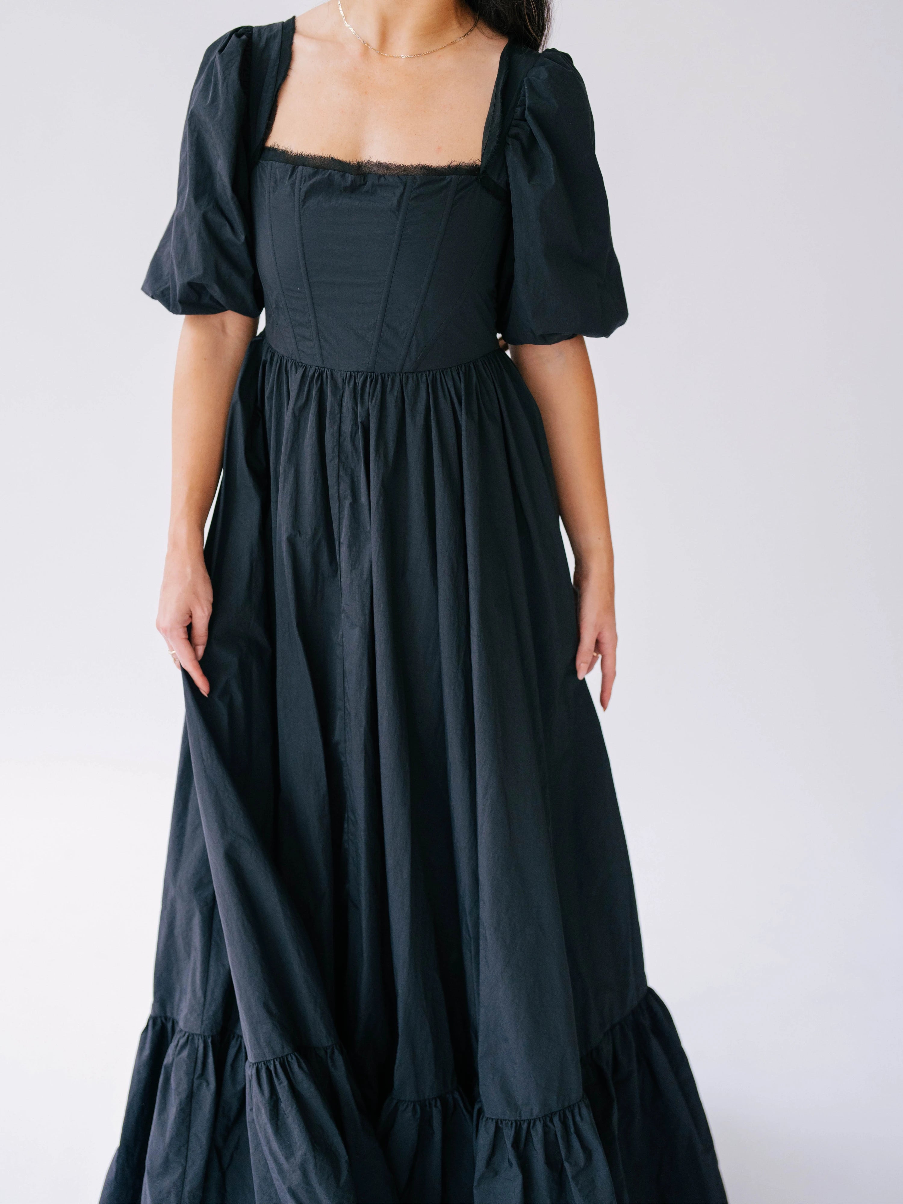 Black taffeta maxi dress with puff sleeves, synthetic boned corset bodice and a ruffled hem.
