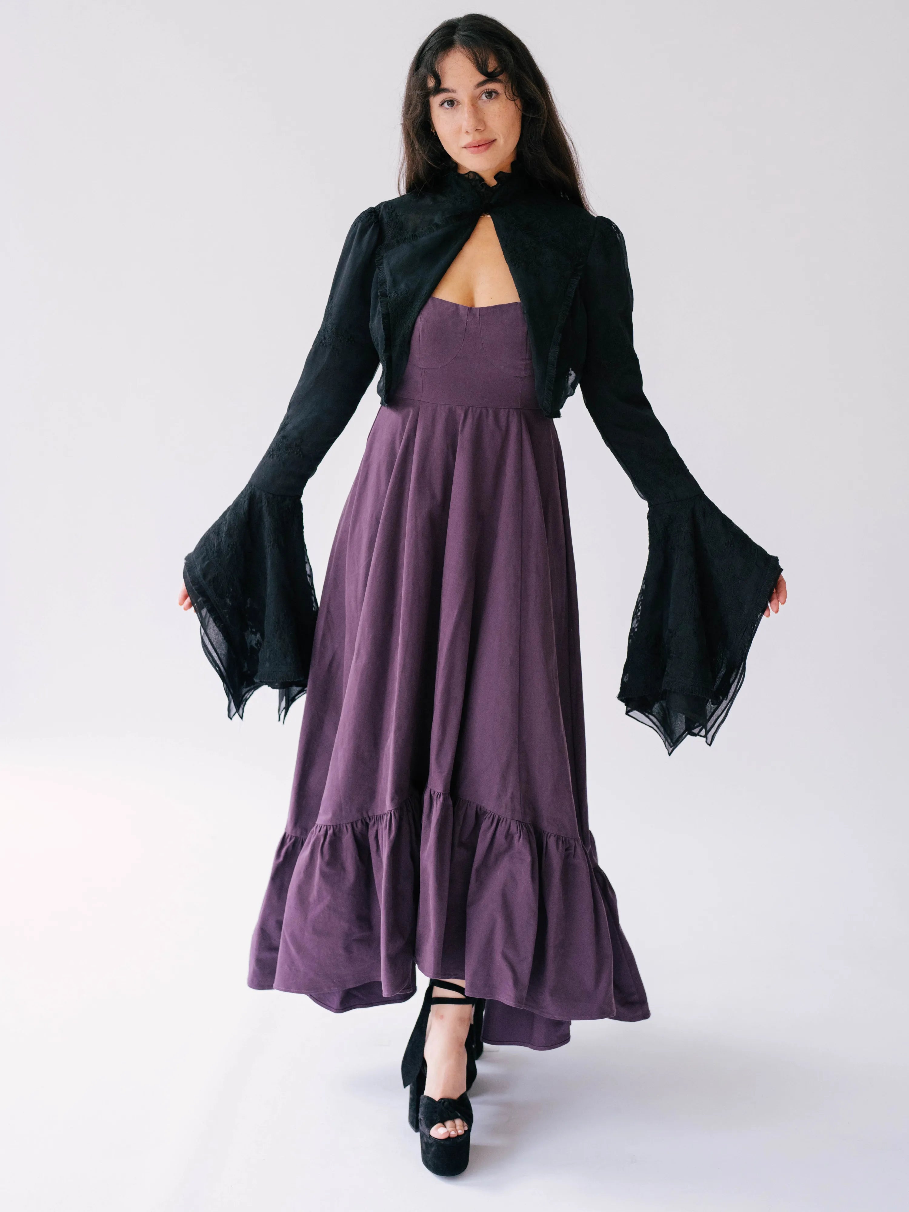 The Lady Elizabeth Midnight Black Victorian Jacket, a black bell sleeve bolero jacket overtop The Cotton Everyday Midi Dress, a regal purple heavy cotton midi dress.