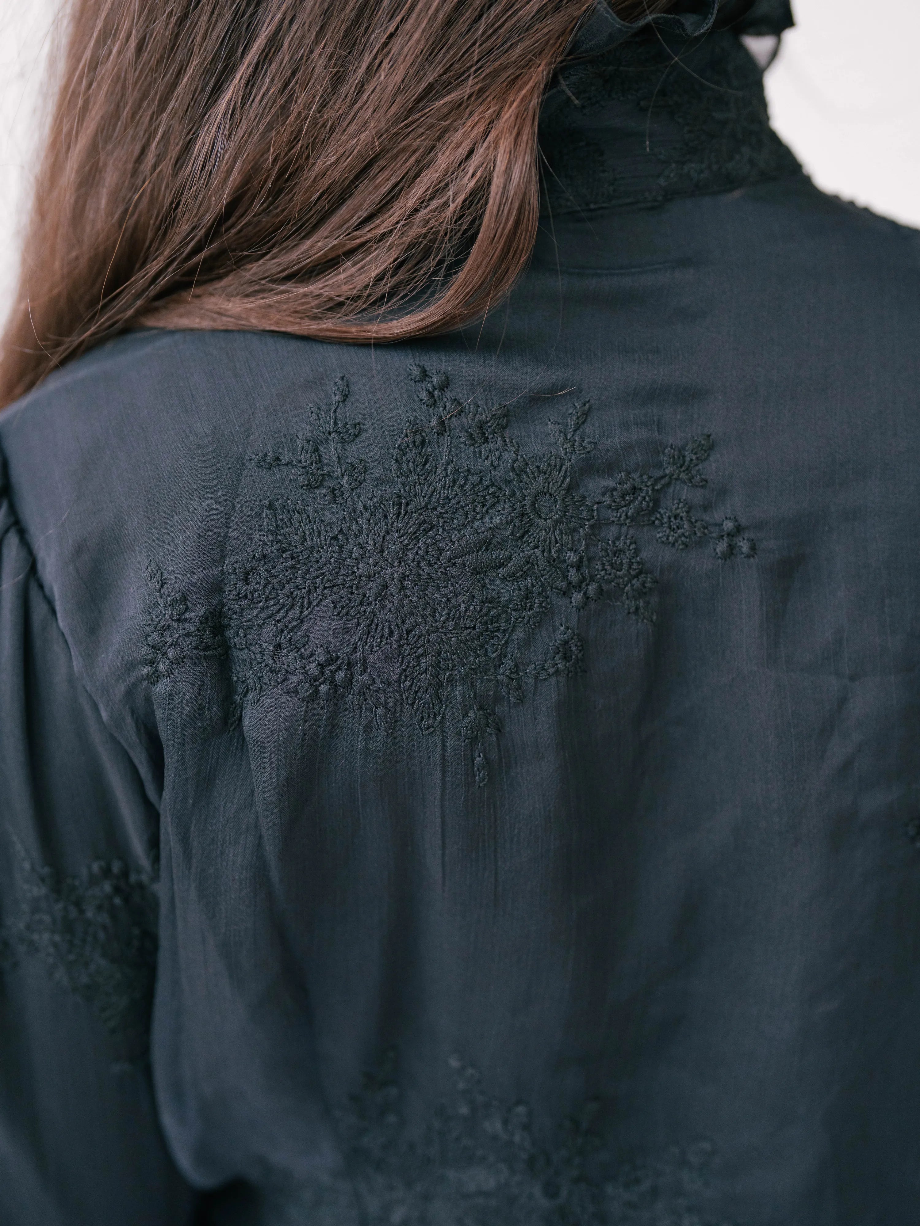 Black jacket with intricate embroidered floral design on the back.