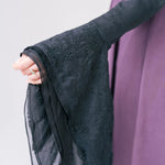 Black lace-trimmed sleeve with delicate floral embroidery.