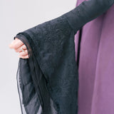 Black lace-trimmed sleeve with delicate floral embroidery.