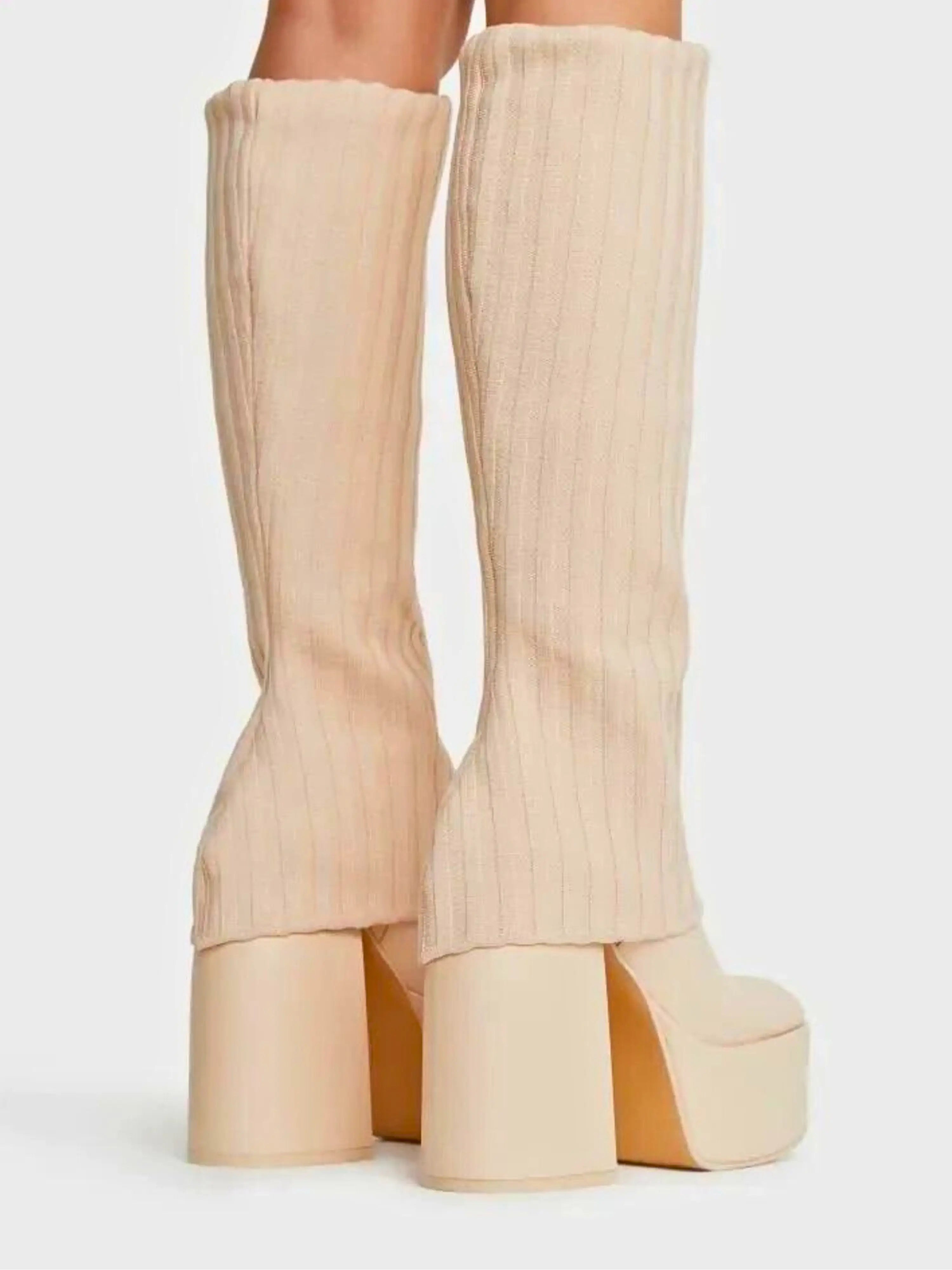 Cream-colored platform boots with chunky heels and ribbed fabric texture.