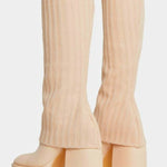 Cream-colored ribbed platform boots with chunky heels.