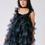 Black ruffled poly organza puff dress with tiered layers.