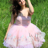 Pink tulle Magnolia Fairy Tutu Dress with lace details worn by a model in a tall grass field for a whimsical effect.