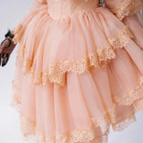 Close-up of the Midnight Symphony Mini Gown's tiered lace ruffles and structured bodice in pumpkin milk organza.