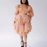 Front view of the Midnight Symphony Mini Gown in pumpkin milk organza with layered lace ruffles, styled with black platform heels.