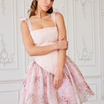 A pink floral print party dress with a fitted corset bodice and flared skirt.
