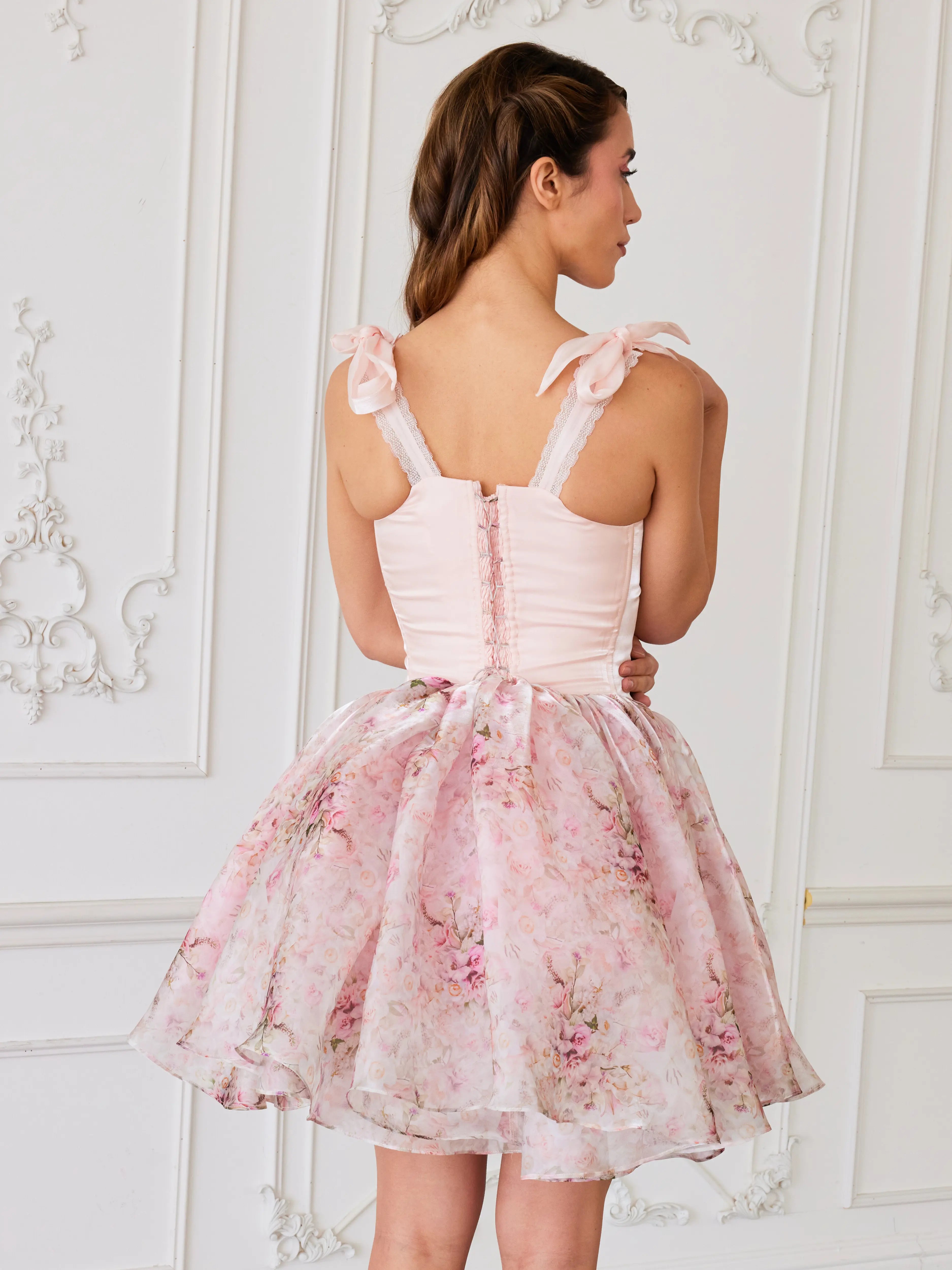 Pink corset mini dress with bow-adorned shoulder straps and a full tulle-organza skirt in the rosewater print.