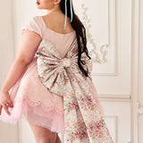 Pink mini dress with a giant bow belt that has a red and pink floral print called Rosewater.