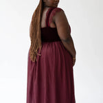 A scarlet red floor-length formal gown with a corset bodice and flowing skirt.