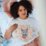 Oversized The Princess Kitten Tee worn with a large pink bow and floral skirt, showcasing a regal kitten graphic on soft cotton fabric.