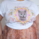 Close-up of The Princess Kitten Tee highlighting the detailed kitten illustration framed by pastel florals and gold accents.