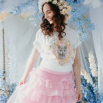 The Princess Kitten Tee styled in a pastel floral scene, paired with a pink tiered skirt and flower crown for a fairytale aesthetic.