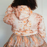 Back view of The Twilight Bloom Sleeper Hoodie showcasing detailed floral print and hood. Styled with a matching floral skirt for a romantic look.