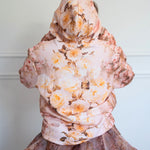 Back of The Twilight Bloom Sleeper Hoodie with hood up, highlighting yellow and blush rose print. Perfect for floral fashion enthusiasts.