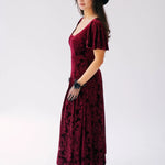 Scarlet red velvet midi dress with butterfly sleeves and a scoop neckline. Paired with short black lace evening gloves