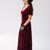 Scarlet red velvet midi dress with butterfly sleeves and a scoop neckline. Paired with short black lace evening gloves