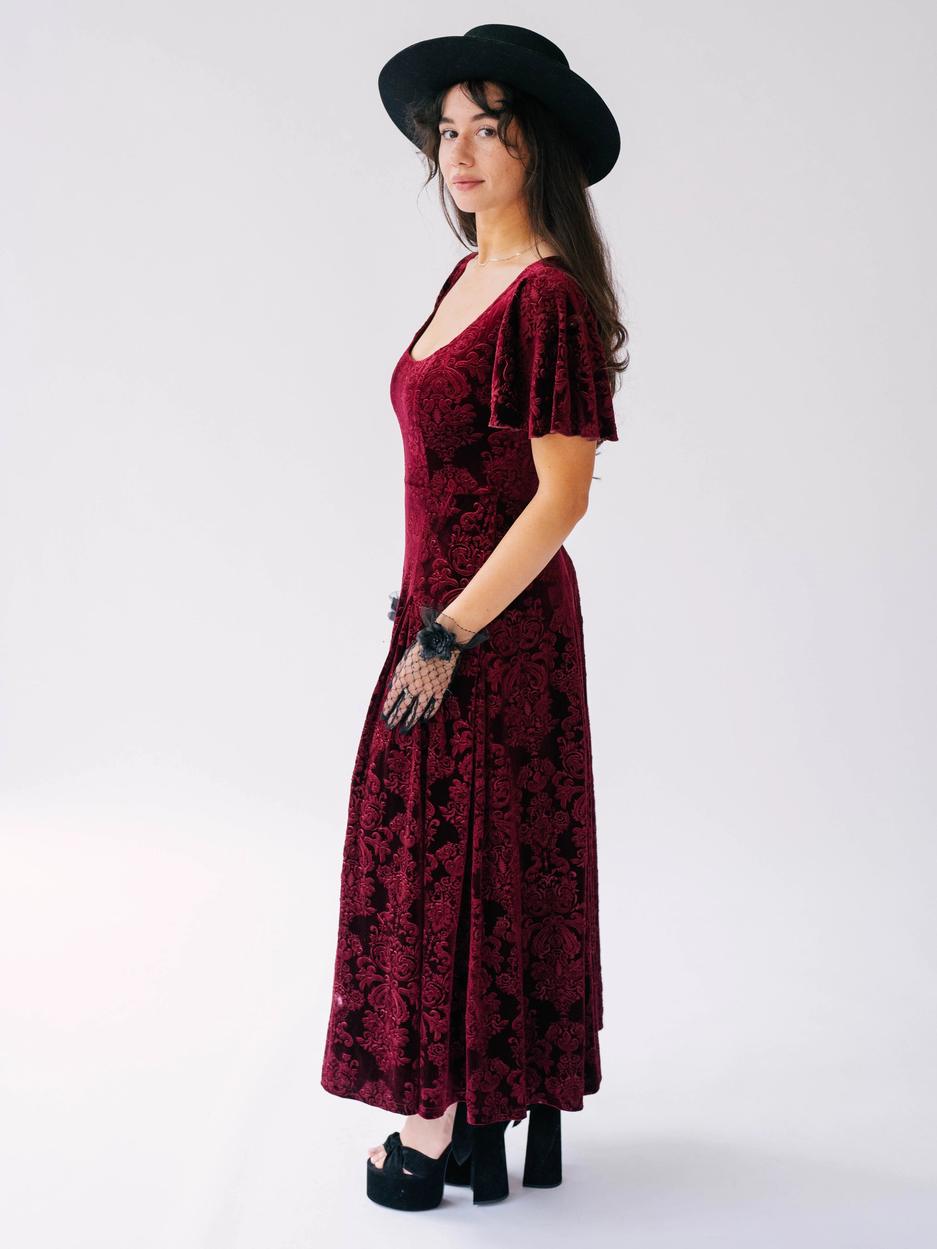 Scarlet red velvet midi dress with butterfly sleeves and a scoop neckline. Paired with short black lace evening gloves