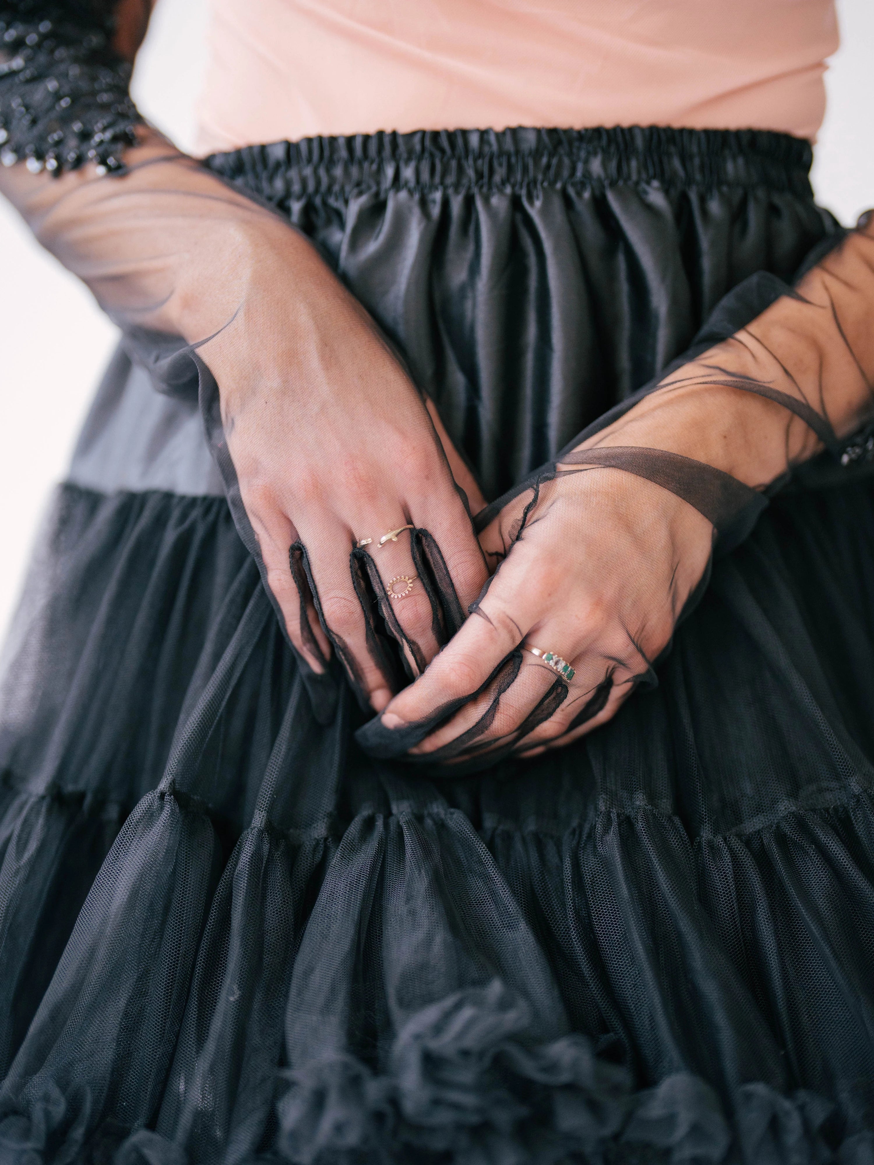The Viola Adorned Lace Gloves resting against a black tulle mini skirt.