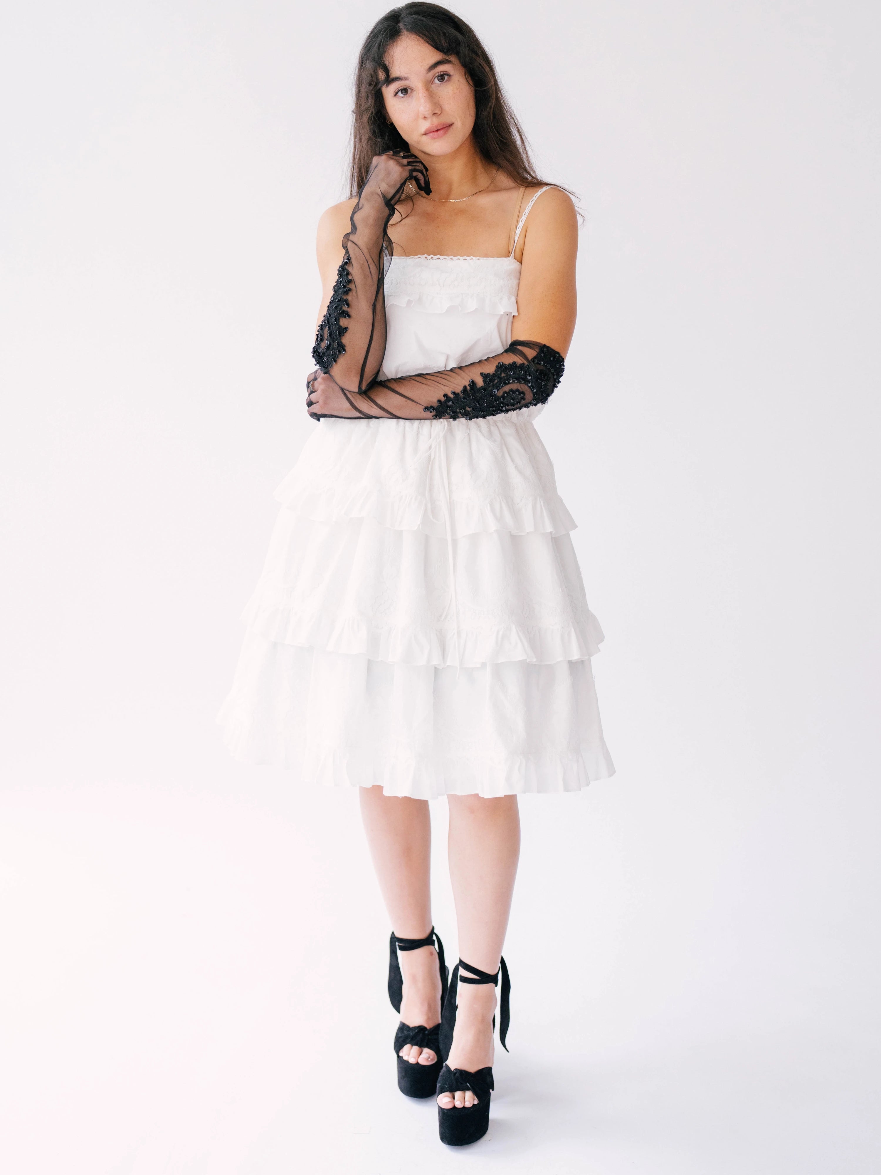 White tiered sundress with spaghetti straps paired with black platform sandals and long black lace opera gloves.