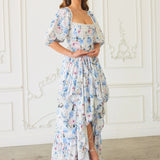 The Wildbloom Josephine Ball Gown has puff sleeves and a ruffled asymmetric hem in light blue and white.