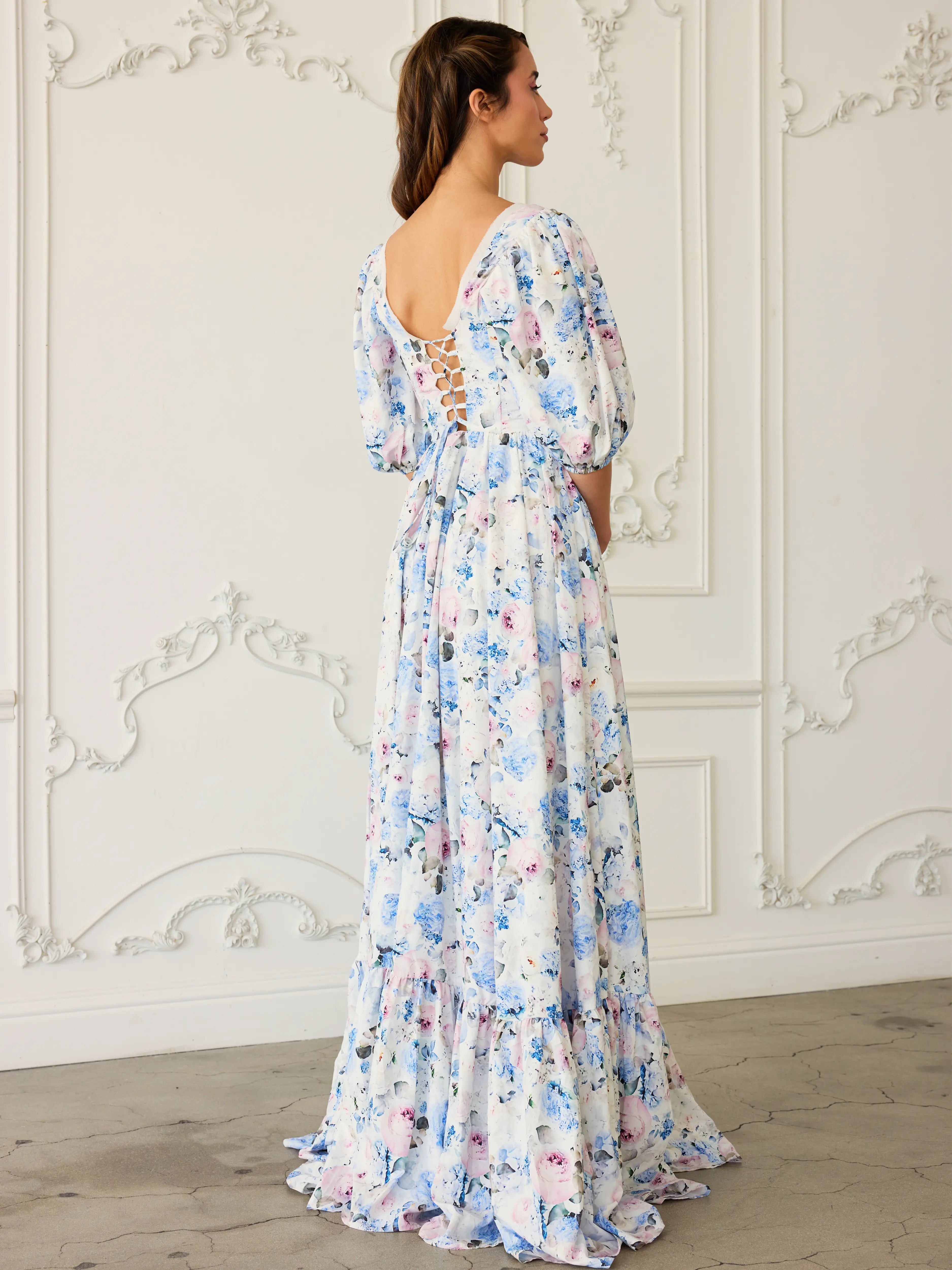 Floor-length floral print ball gown with puff sleeves and an open back corset design.