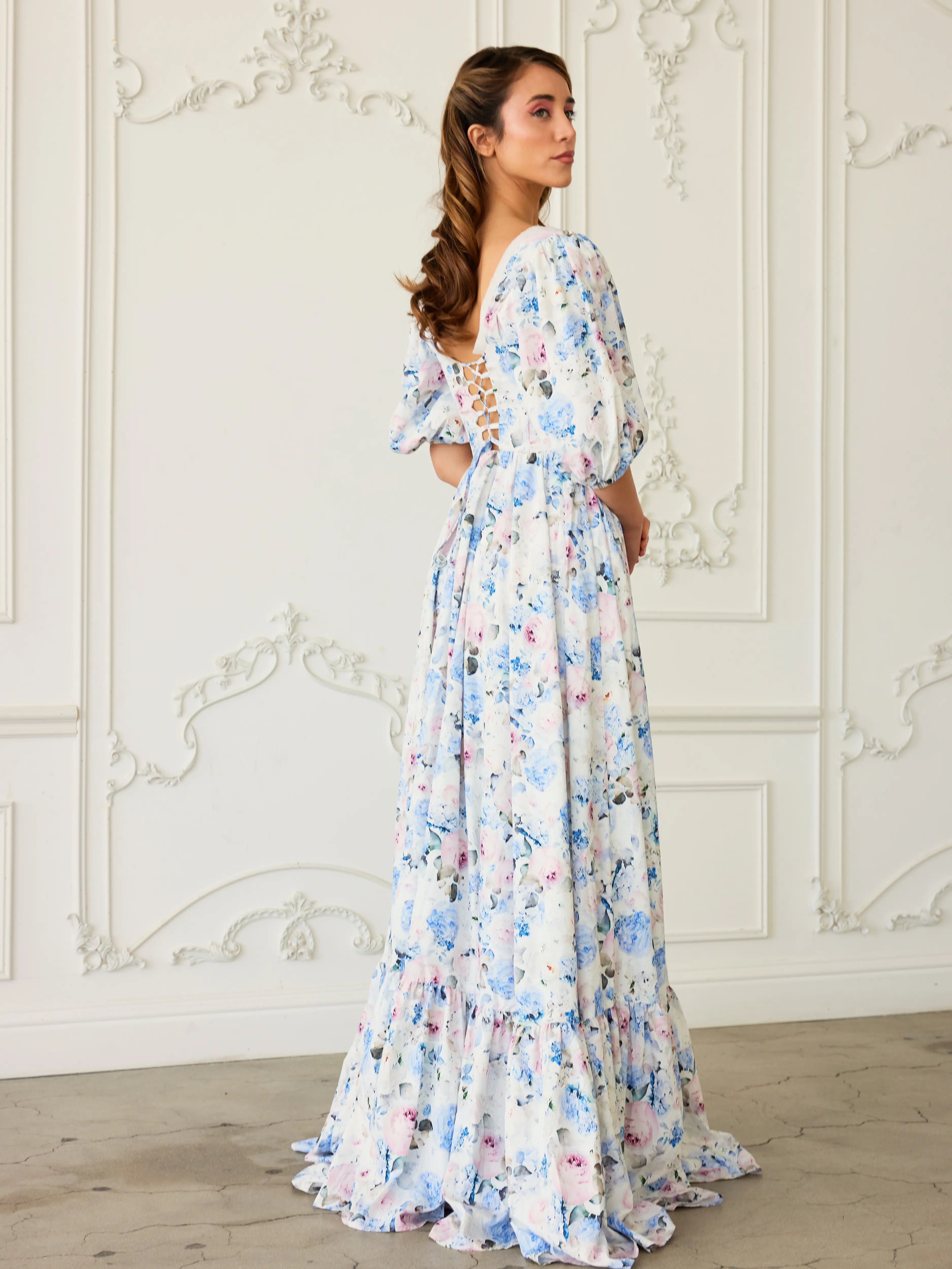 Corset maxi dress with ruffled tiers and puff sleeves in a white and blue floral print called Wildbloom.