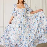 A floral print ball gown with puff sleeves and a square neckline in white, blue and pink tones.