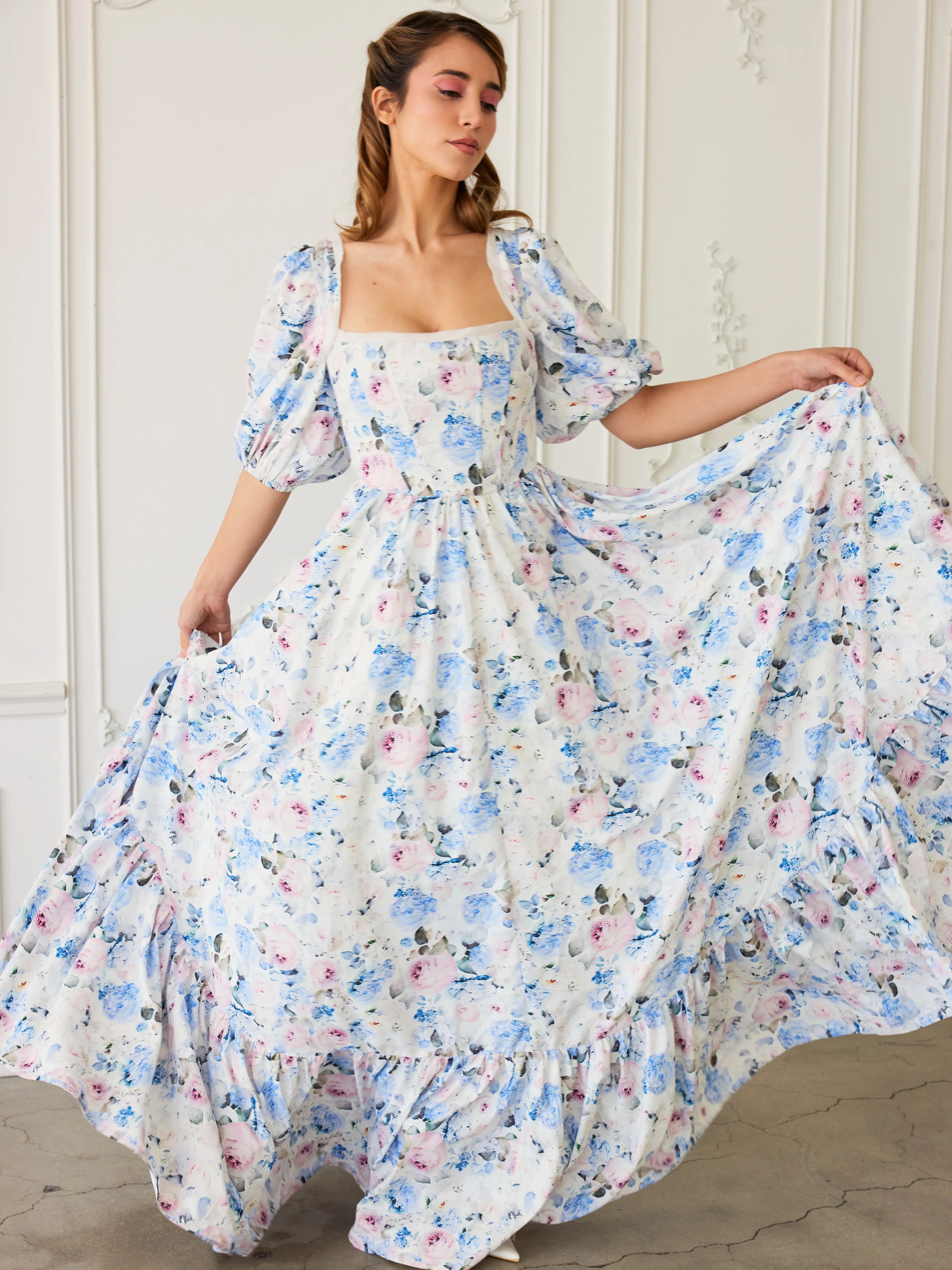 A floral print ball gown with puff sleeves and a square neckline in white, blue and pink tones.