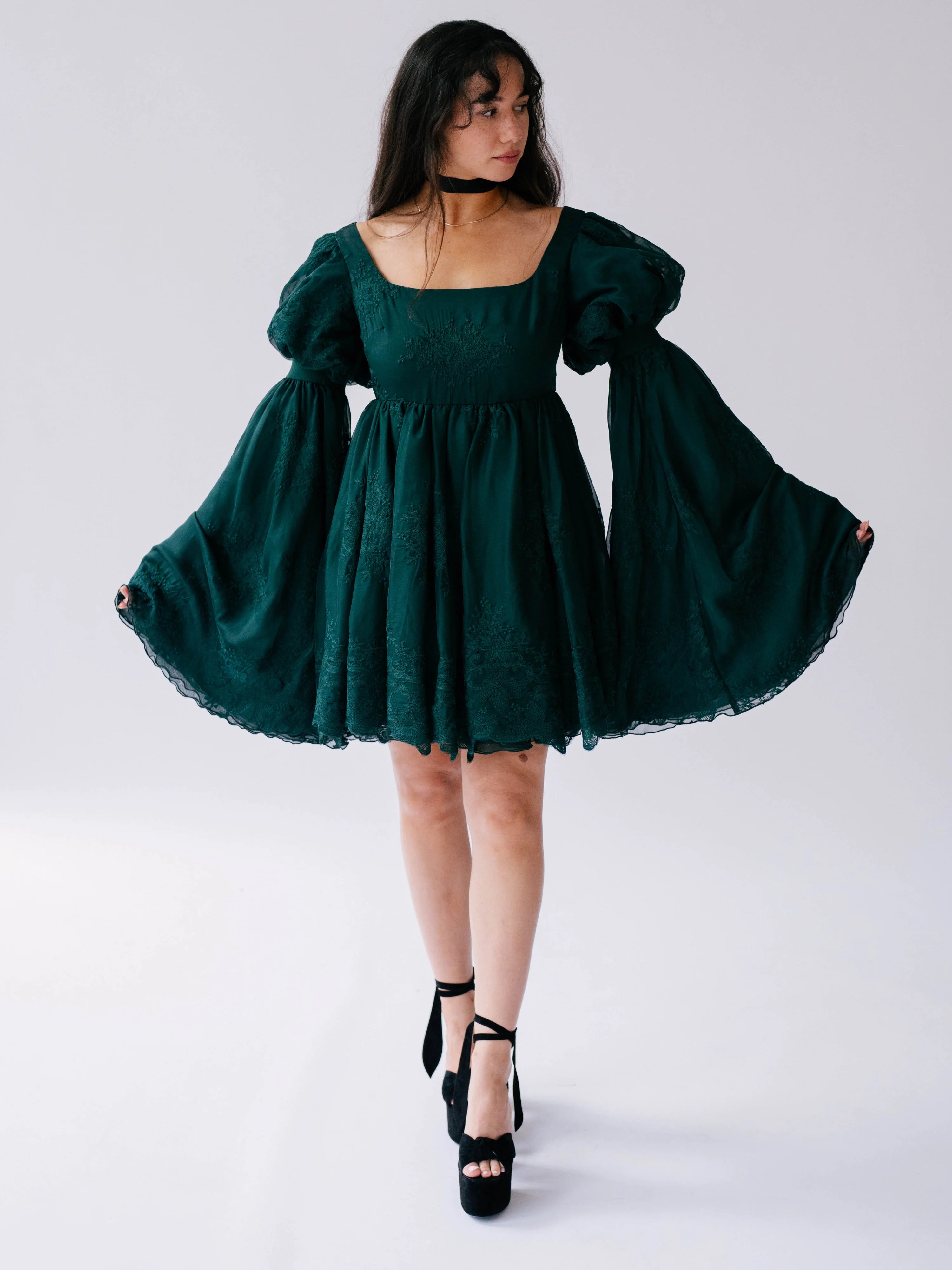 Emerald green bell sleeve mini dress with puffy long sleeves and a ruffled hem.