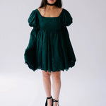 Dark emerald green mini dress with bell sleeves and a black choker necklace.