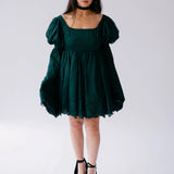 Dark emerald green mini dress with bell sleeves and a black choker necklace.